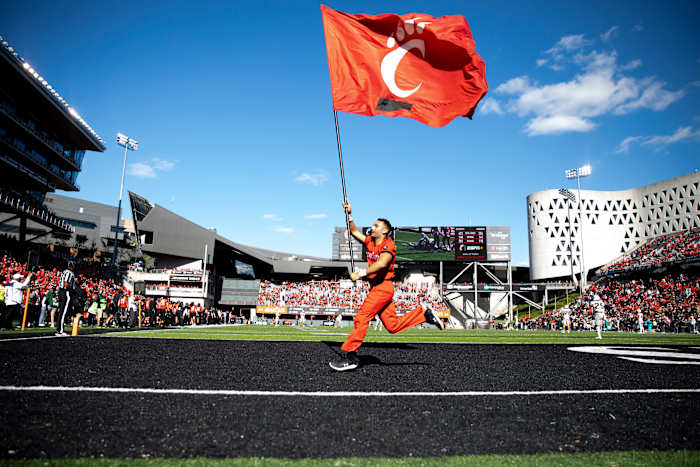 Cincinnati Bearcats cheerleader runs with a flag in the second half of the NCAA football game on Saturday, Oct. 15, 2021, at Nippert Stadium in Cincinnati. Cincinnati Bearcats defeated UCF Knights 56-21. Ucf Knights At Cincinnati Bearcats 163